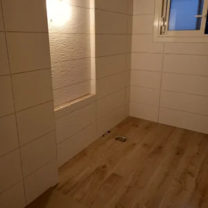 Photo d'une salle de bain avec du carrelage blanc et aspect bois.