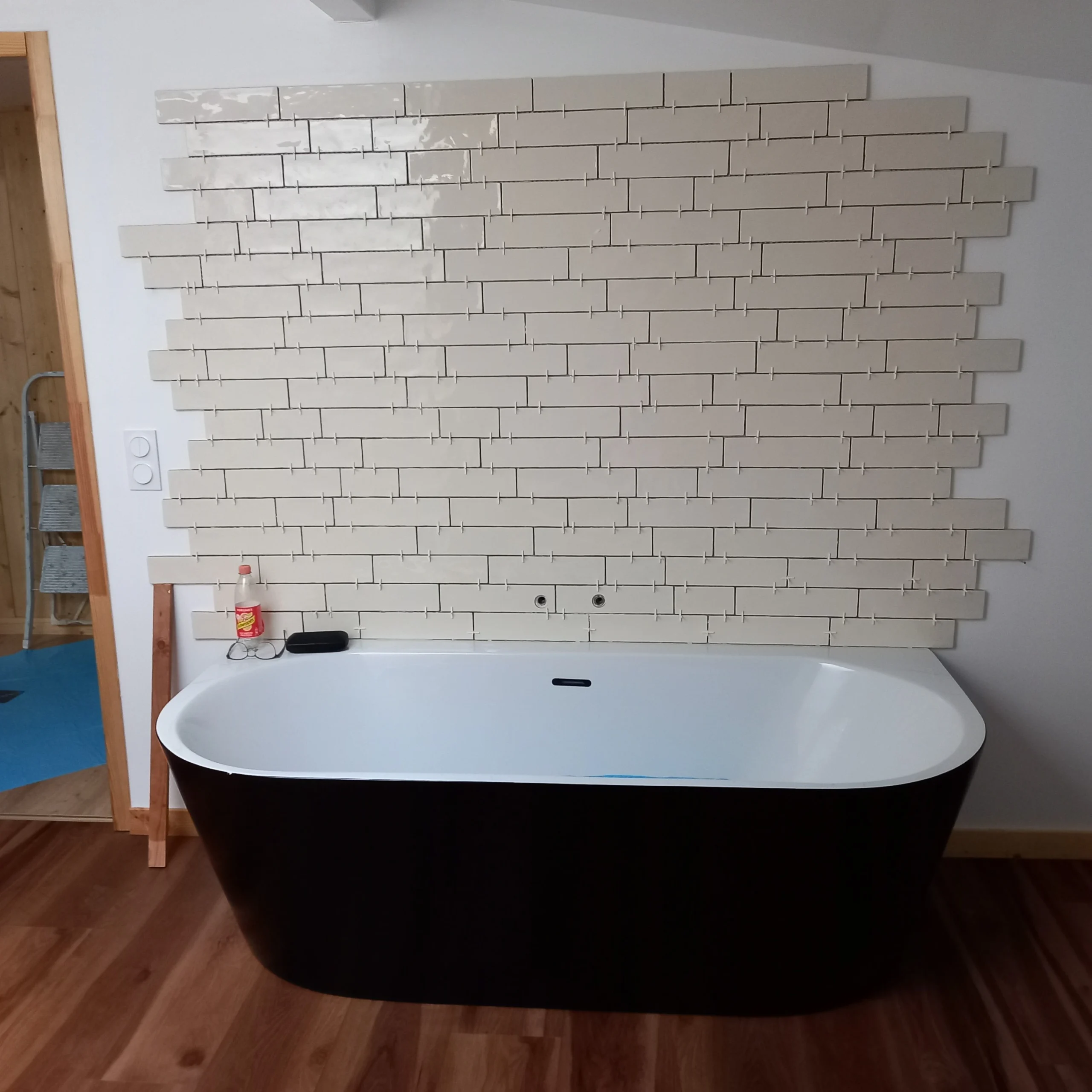 Photo de carrelage blanc au dessus d'une baignoire.