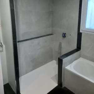 Photo d'une salle de bain, avec du carrelage gris clair et noir.