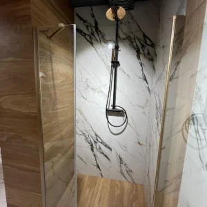 Photo d'une douche avec du carrelage aspect marbre et bois.