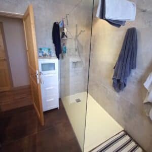 Photo d'une douche avec un mur en carrelage gris et un sol en carrelage marron.